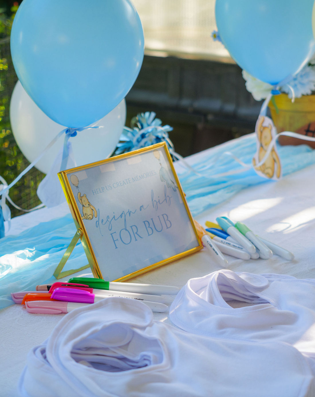 Winnie the Pooh themed baby shower styled with a blue arch backdrop and silk florals